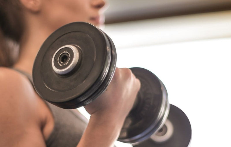 Woman Holding Dumbells In Both Hands